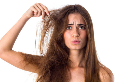 Woman with dry, damaged hair caused by hard water, looking frustrated