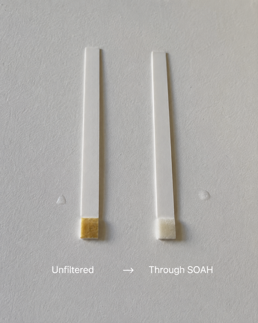 Side-by-side chlorine test strips comparing unfiltered shower water with water passed through a SOAH filtered shower head