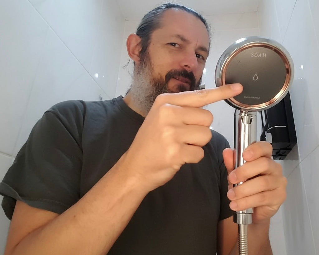Bearded man in Dubai holding the SOAH Chrome Edition vitamin C shower head, showing easy installation and strong water pressure